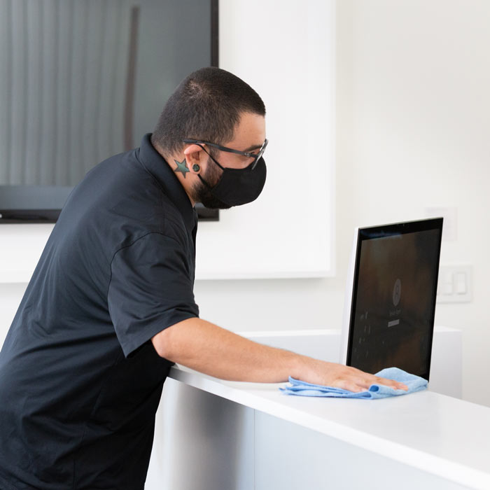 Image of Servicon specialist disinfecting a work station
